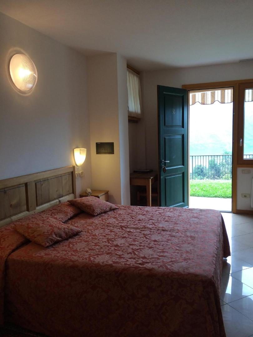 Albergo Rusall – camera dubla clasica cu cuvertura rosu-teracota si usa spre terasa cu vedere la gradina, Tremezzo Albergo Rusall – camera dubla clasica cu cuvertura rosu-teracota si usa spre terasa cu vedere la gradina, Tremezzo