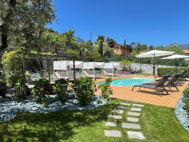 Charming Bellagio Boutique Hotel – piscina exterioara sezoniera cu sezlonguri si paturi de zi albe, gradina mediteraneana cu palmier si munti, Bellagio