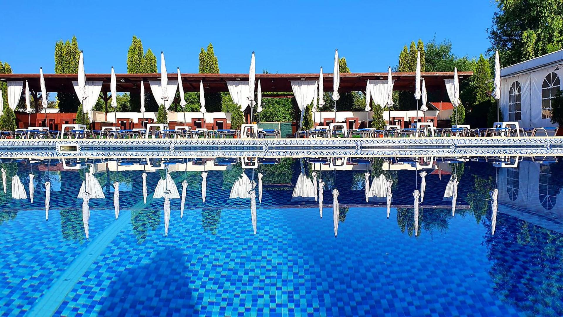 Piscina exterioară a GARDEN Club Brașov văzută de sus, cu grădina din jur Piscina exterioară a GARDEN Club Brașov văzută de sus, cu grădina din jur