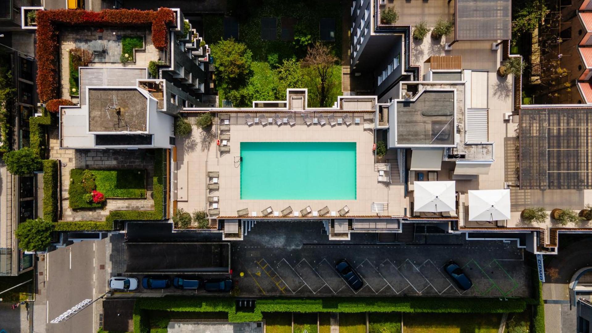 Hotel Como – piscina sezoniera pe acoperis vazuta din drona, cu gradini verzi si cladiri din jur, Como Hotel Como – piscina sezoniera pe acoperis vazuta din drona, cu gradini verzi si cladiri din jur, Como