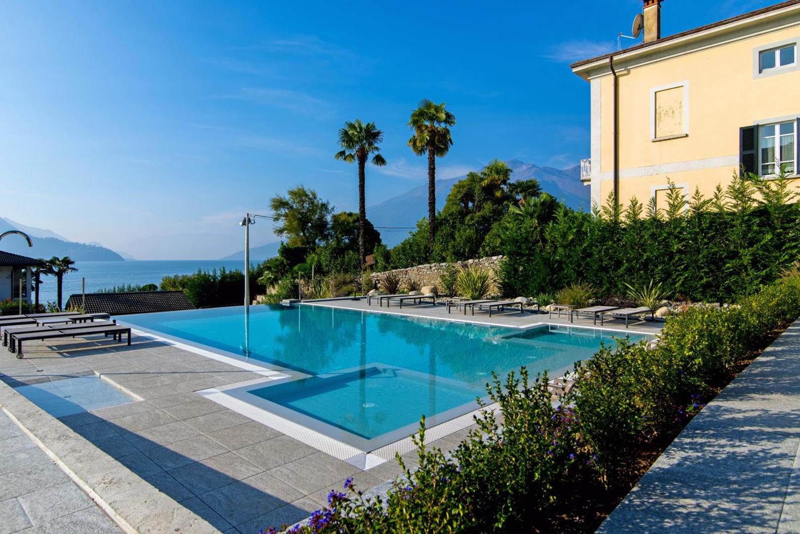 Hotel Domaso – piscina exterioară cu șezlonguri, palmieri și vila hotelului, Domaso Hotel Domaso – piscina exterioară cu șezlonguri, palmieri și vila hotelului, Domaso