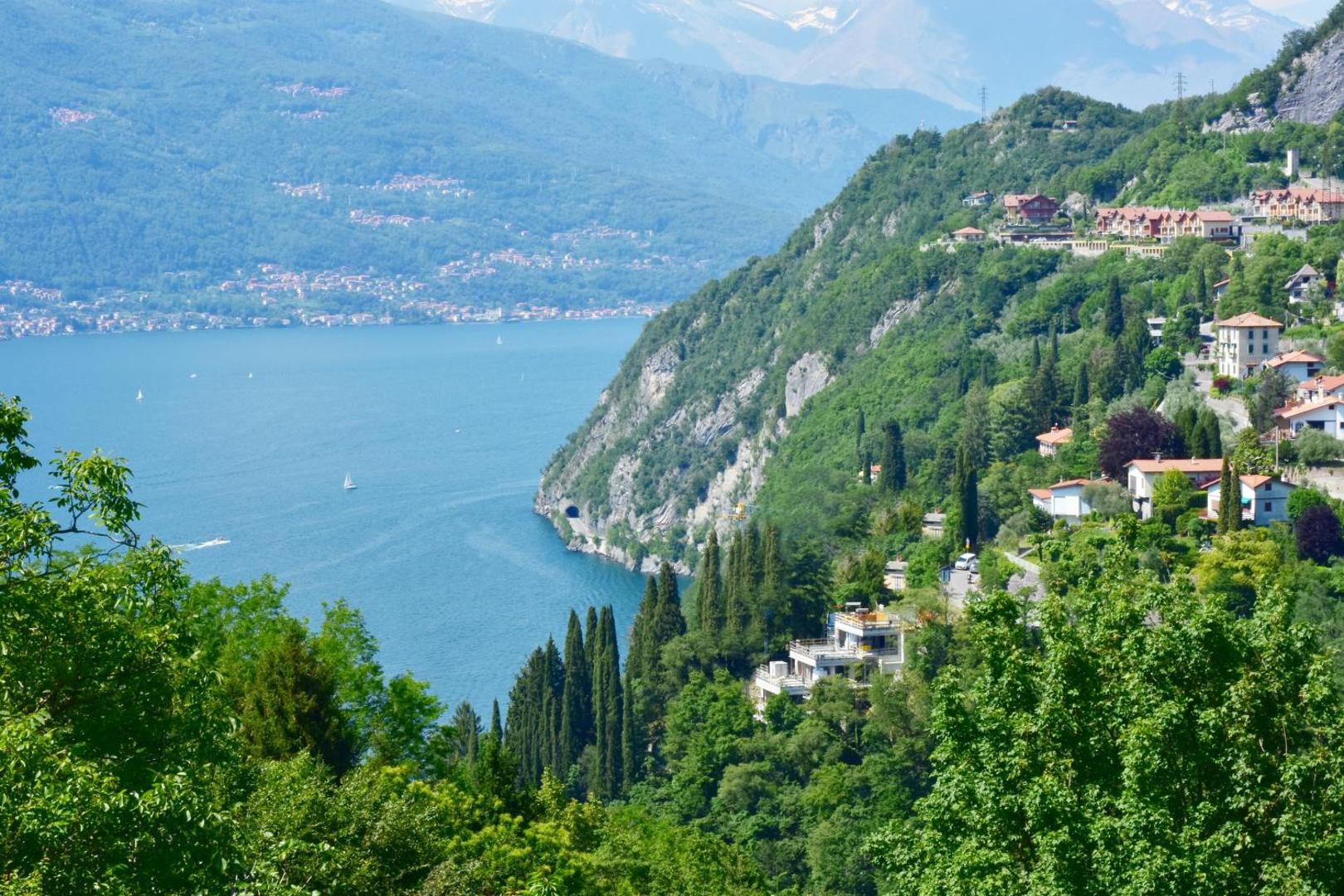 Hotel Diffuso Il Portichetto Perledo – panorama Lacul Como vara cu apa albastra, chiparosi si sate pe malul vestic, vedere de pe dealurile Perledo Hotel Diffuso Il Portichetto Perledo – panorama Lacul Como vara cu apa albastra, chiparosi si sate pe malul vestic, vedere de pe dealurile Perledo