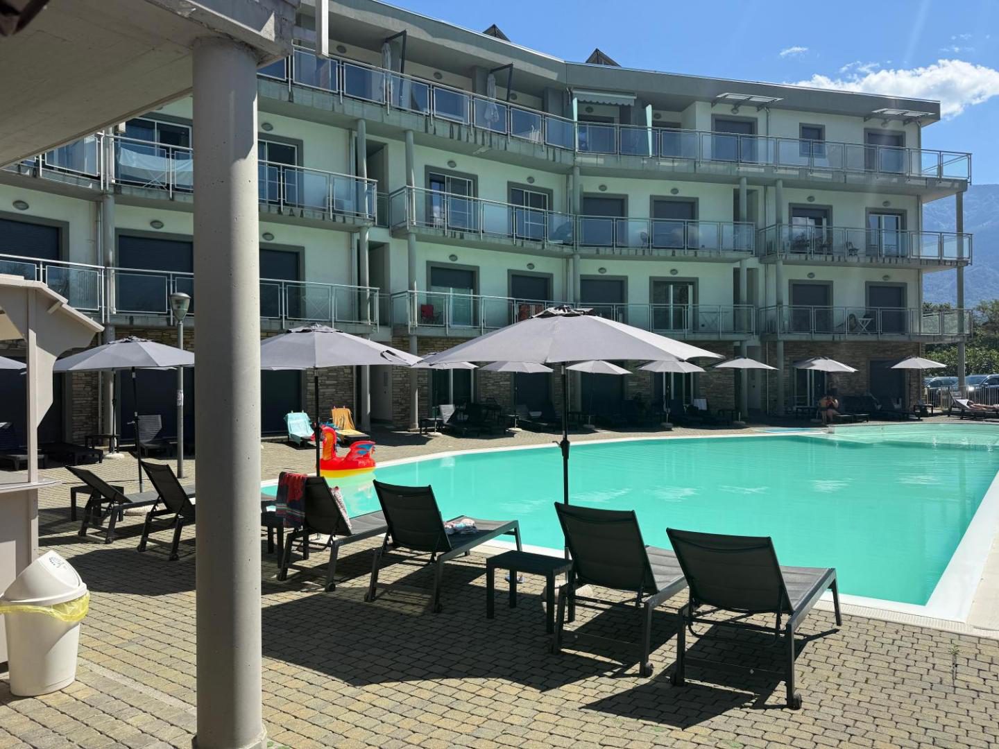 Residence Alessandra – piscina infinita exterioară cu șezlonguri și umbrele în fața clădirii, Domaso