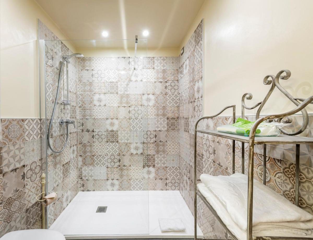 Residence Lenno – baie cu dus si faianta patchwork decorativa in tonuri bej, suport prosoape din fier forjat, Lenno Residence Lenno – baie cu dus si faianta patchwork decorativa in tonuri bej, suport prosoape din fier forjat, Lenno