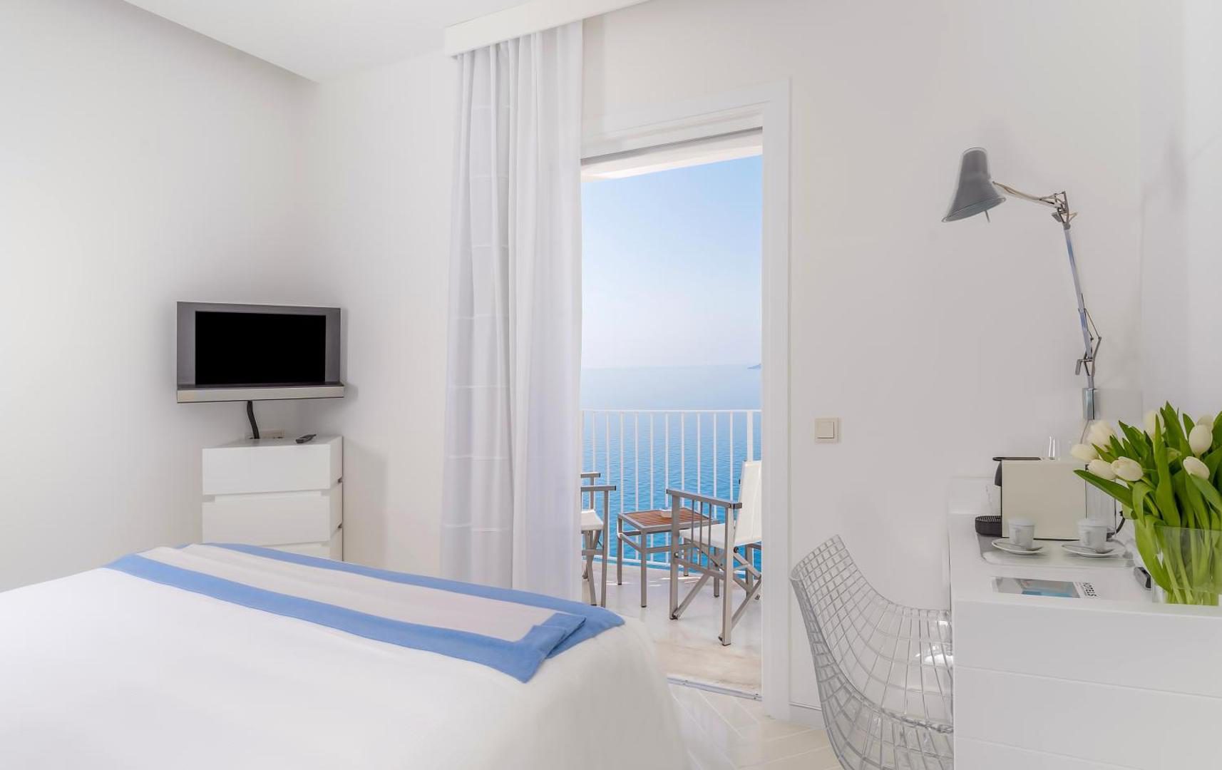 Casa Angelina Praiano – dormitor alb minimalist cu balcon deschis si vedere directa la mare Casa Angelina Praiano – dormitor alb minimalist cu balcon deschis si vedere directa la mare