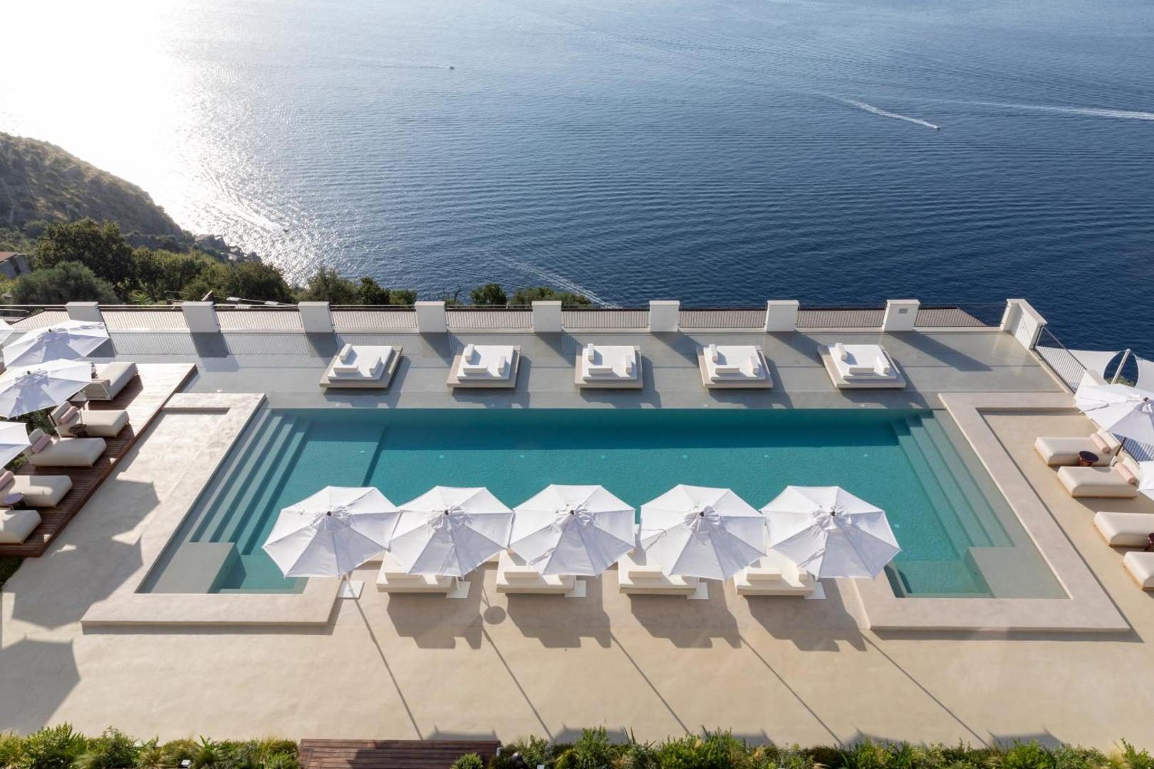 Furore Grand Hotel – piscina exterioara cu sezlonguri suspendate deasupra marii Furore Grand Hotel – piscina exterioara cu sezlonguri suspendate deasupra marii
