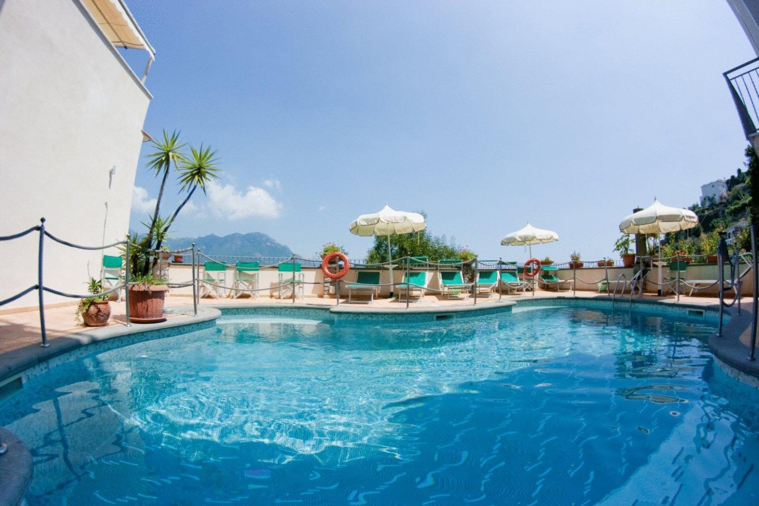 Hotel Bonadies Ravello – piscina exterioara ziua, cu sezlonguri si umbrele, vedere la munte Hotel Bonadies Ravello – piscina exterioara ziua, cu sezlonguri si umbrele, vedere la munte