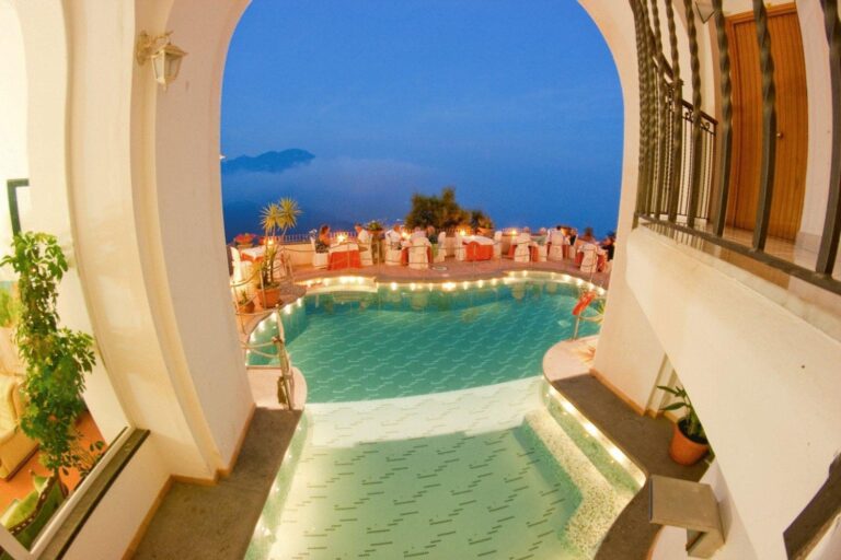 Hotel Bonadies Ravello – piscina la lumina serii, vazuta printr-un arc, cu cina eleganta pe terasa
