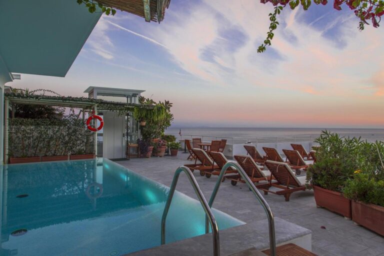Hotel Marina Riviera Amalfi – piscina pe acoperis la apus, sezlonguri din lemn si vedere panoramica la mare