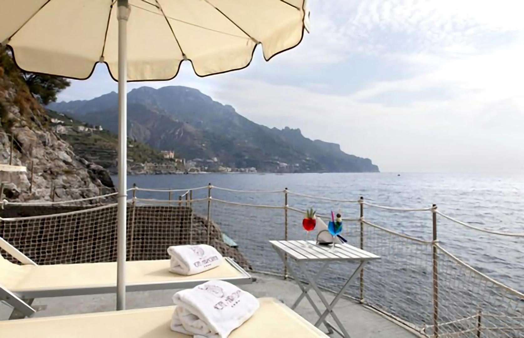 Ravello Art Hotel Marmorata – terasa la malul marii cu sezlonguri, umbrela si cocktailuri Ravello Art Hotel Marmorata – terasa la malul marii cu sezlonguri, umbrela si cocktailuri