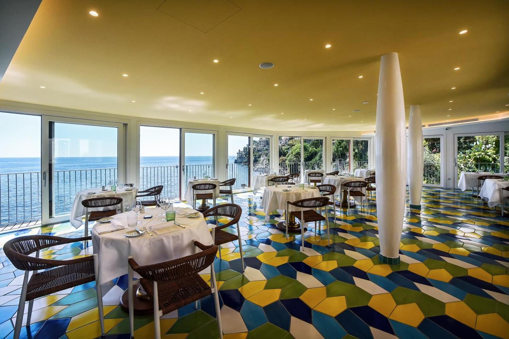 Ravello Art Hotel Marmorata – restaurant L'Antica Cartiera cu pardoseala hexagonala colorata si pereti vitrati spre mare Ravello Art Hotel Marmorata – restaurant L'Antica Cartiera cu pardoseala hexagonala colorata si pereti vitrati spre mare
