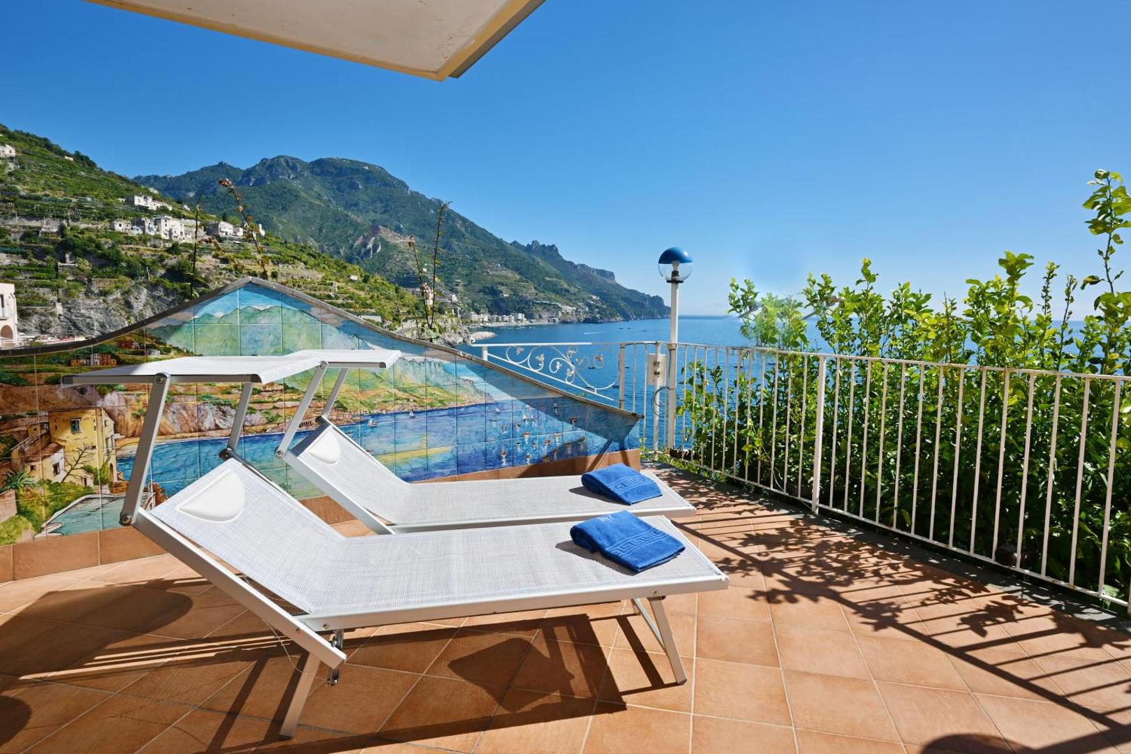 Ravello Art Hotel Marmorata – sezlonguri pe terasa cu mozaic mural si vedere panoramica la mare Ravello Art Hotel Marmorata – sezlonguri pe terasa cu mozaic mural si vedere panoramica la mare