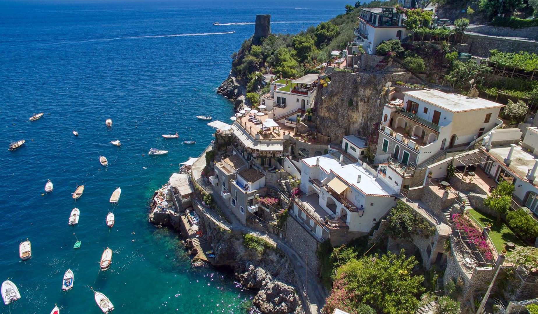 Hotel Onda Verde Praiano – vedere aeriana a hotelului cocotat pe stanca deasupra golfului cu barci Hotel Onda Verde Praiano – vedere aeriana a hotelului cocotat pe stanca deasupra golfului cu barci