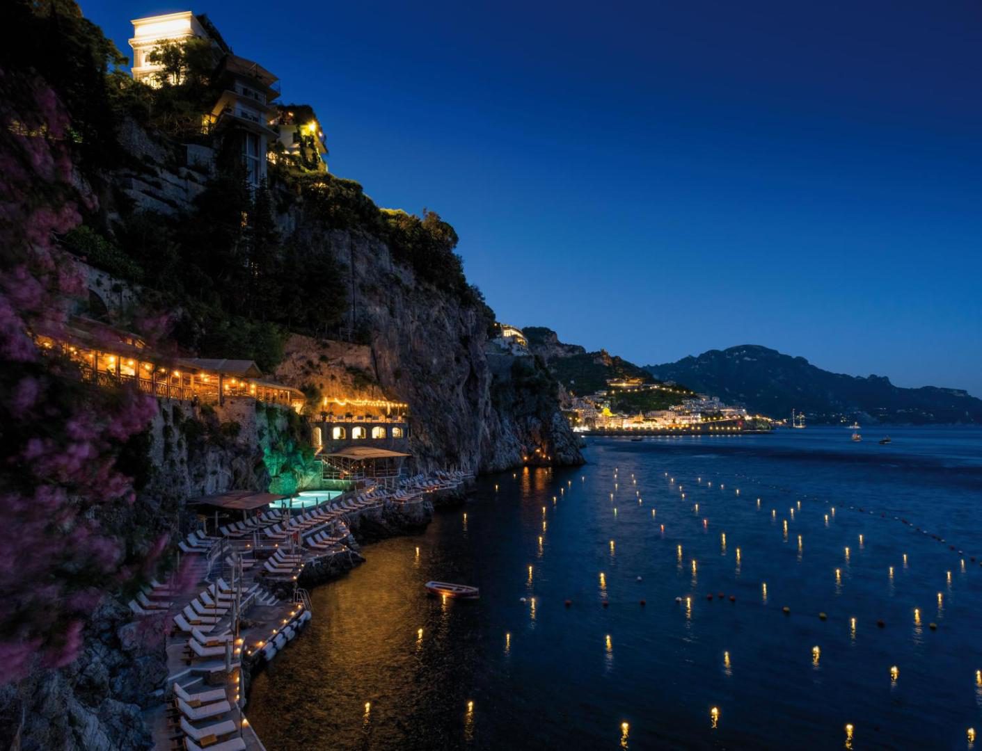 Hotel Santa Caterina Amalfi – piscina iluminata seara, sapata in stanca deasupra marii, cu vedere la luminile golfului Amalfi Hotel Santa Caterina Amalfi – piscina iluminata seara, sapata in stanca deasupra marii, cu vedere la luminile golfului Amalfi