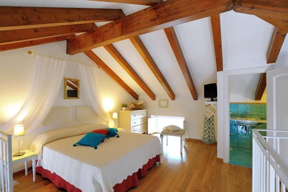 Loft Apartments Amalfi – dormitor tip mansarda cu grinzi de lemn si baldachin Loft Apartments Amalfi – dormitor tip mansarda cu grinzi de lemn si baldachin