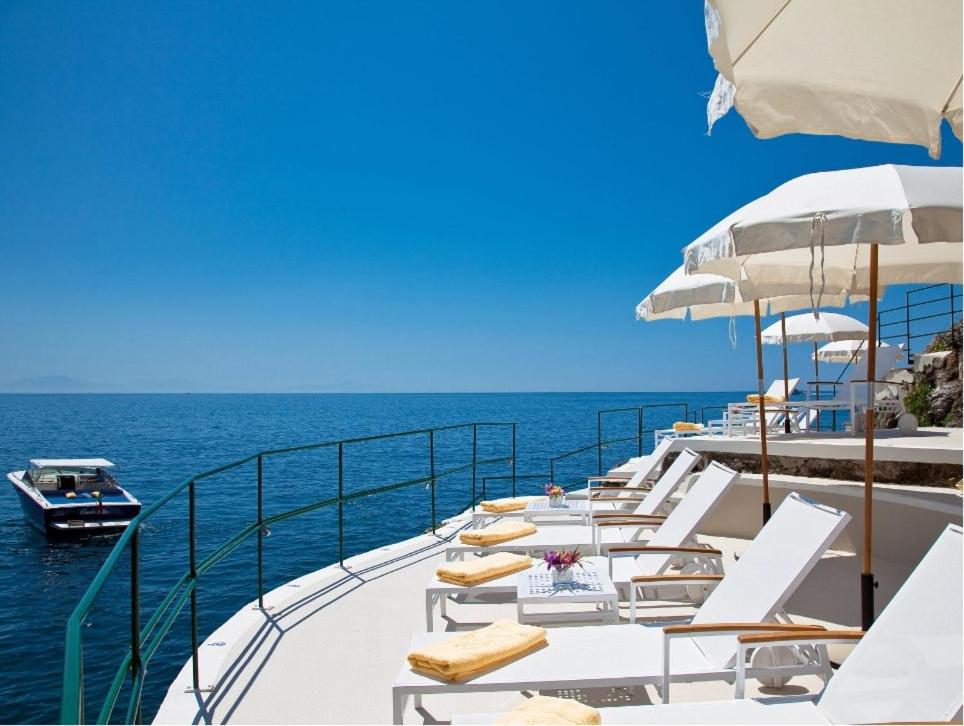 Palazzo Avino Ravello – terasa cu sezlonguri pe stanca, vedere la mare si barca Palazzo Avino Ravello – terasa cu sezlonguri pe stanca, vedere la mare si barca