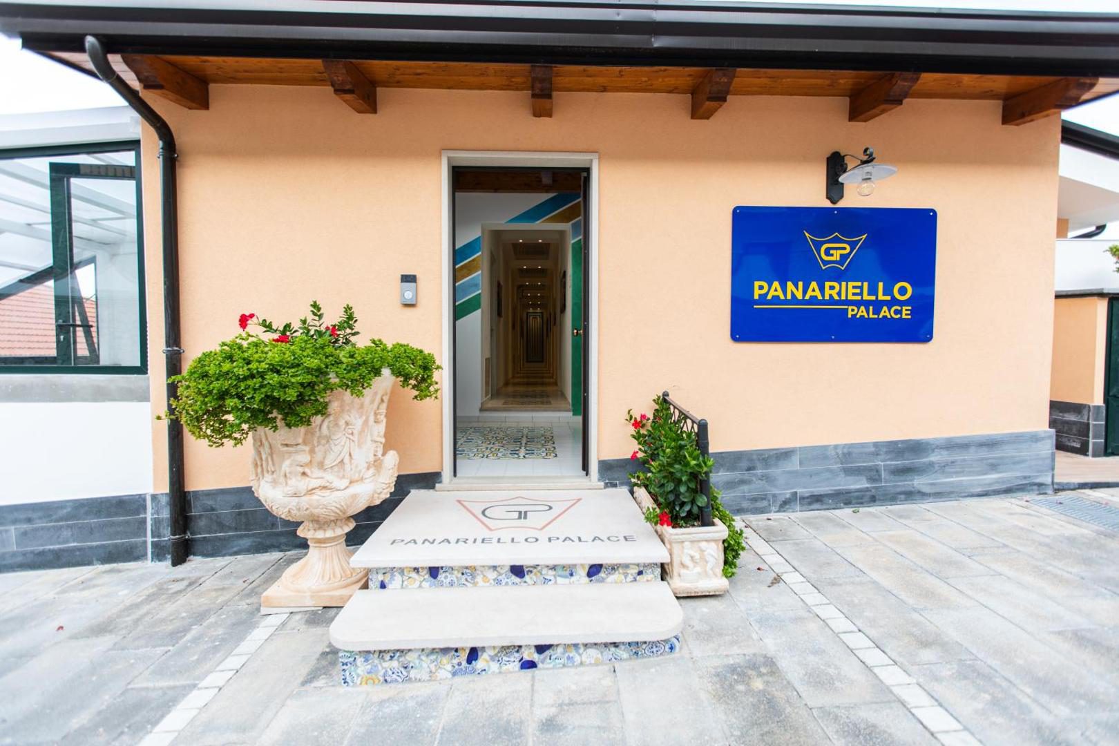 Panariello Palace Agerola – intrarea proprietatii cu firma albastra si ghivece cu flori Panariello Palace Agerola – intrarea proprietatii cu firma albastra si ghivece cu flori
