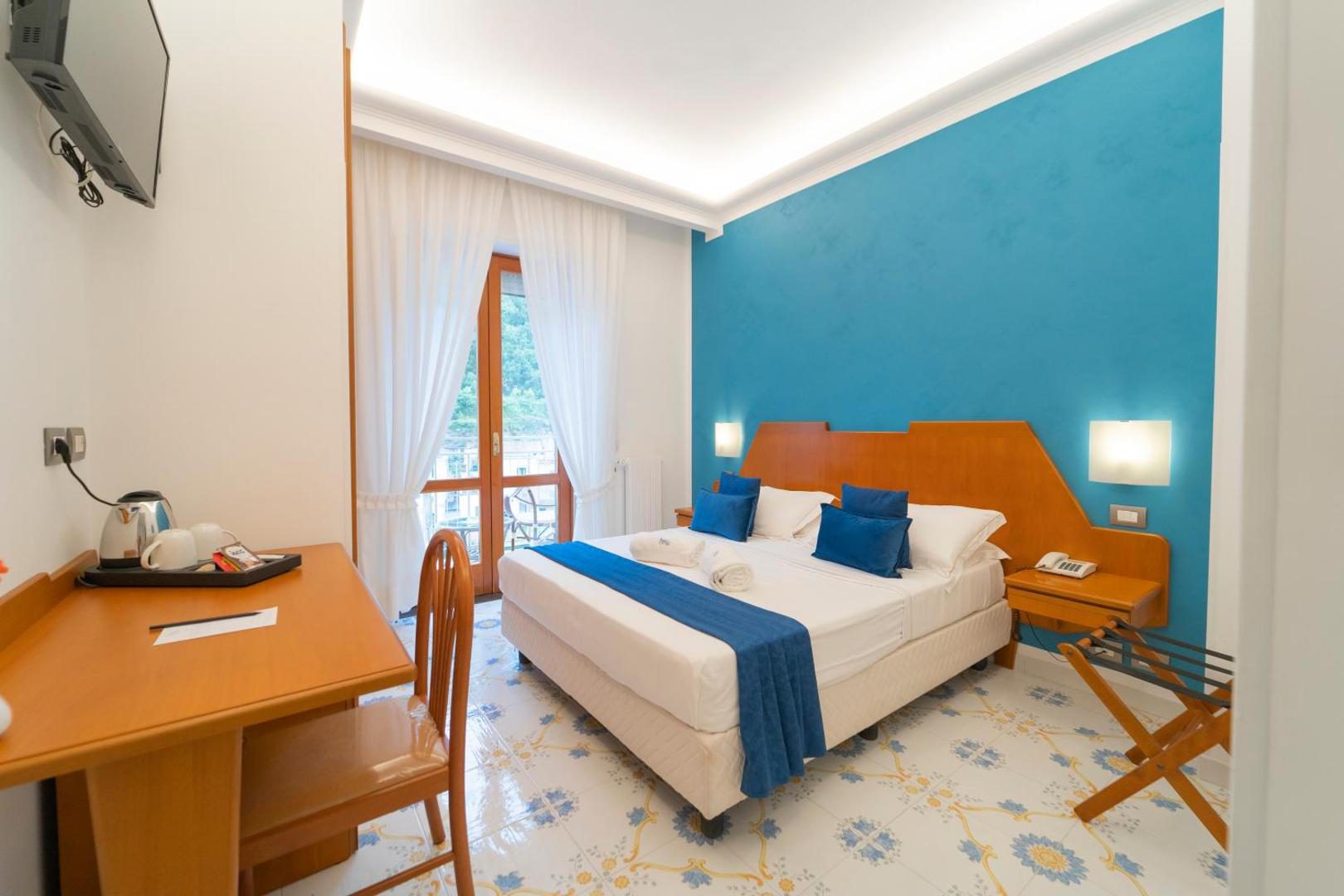 Hotel San Pietro Maiori – dormitor cu perete albastru si balcon cu vedere Hotel San Pietro Maiori – dormitor cu perete albastru si balcon cu vedere
