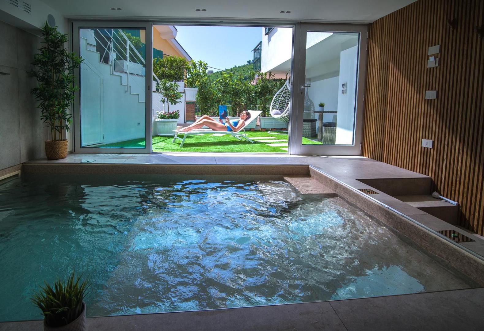 SG Suite & Spa Vietri – piscina cu vedere spre gradina cu sezlonguri si leagan suspendat SG Suite & Spa Vietri – piscina cu vedere spre gradina cu sezlonguri si leagan suspendat
