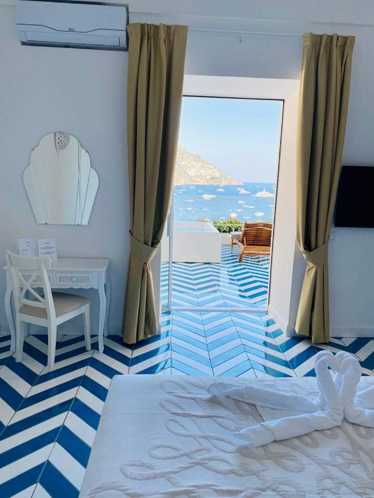 Villa Diamond Luxury Suite Positano – dormitor cu pardoseala geometrica si vedere directa la mare Villa Diamond Luxury Suite Positano – dormitor cu pardoseala geometrica si vedere directa la mare