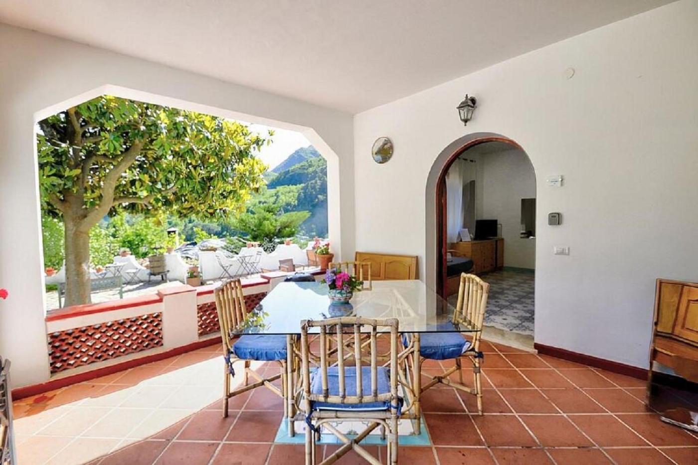 Villa Inn Costa Tramonti – terasa acoperita cu masa de mese si vedere la munti Villa Inn Costa Tramonti – terasa acoperita cu masa de mese si vedere la munti