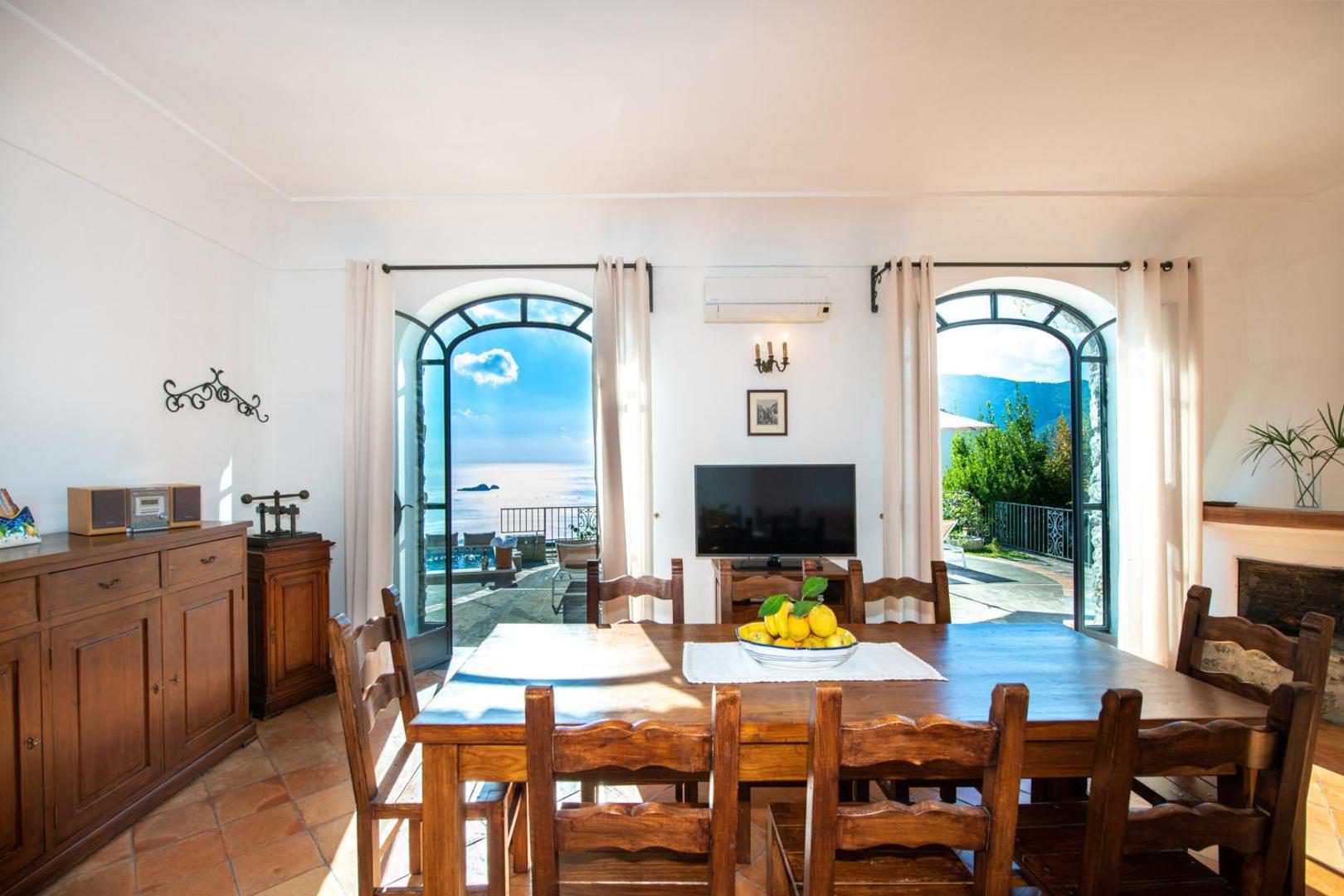 Ville Olimpo Nocelle – sufragerie cu usi arcuite spre terasa si piscina, vedere la mare Ville Olimpo Nocelle – sufragerie cu usi arcuite spre terasa si piscina, vedere la mare