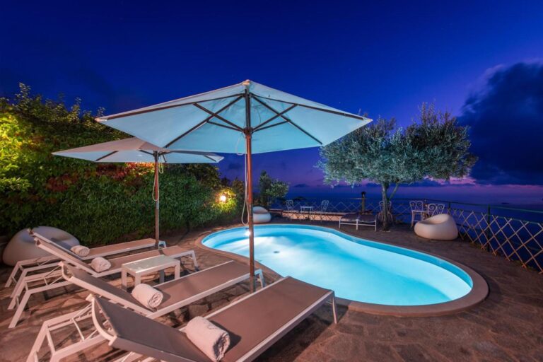Ville Olimpo Nocelle – piscina exterioara pe terasa, iluminata seara, cu sezlonguri si vedere la mare