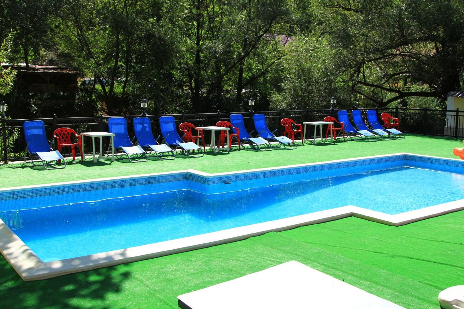 Pension Noblesse – piscina exterioară cu șezlonguri și munții din jur