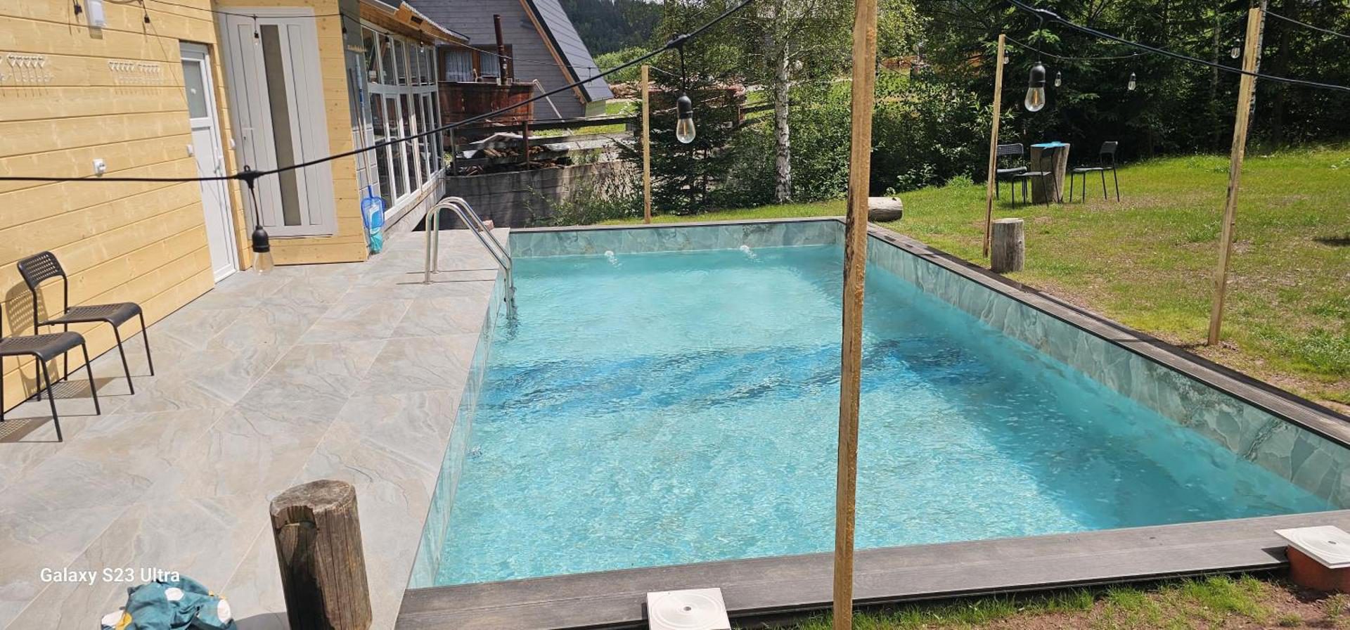Cabana din Vale Arieșeni – piscina exterioară și terasa placată de lângă cabană Cabana din Vale Arieșeni – piscina exterioară și terasa placată de lângă cabană
