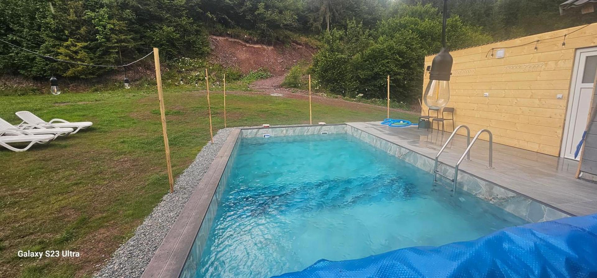 Cabana din Vale Arieșeni – piscina exterioară și zona cu șezlonguri de pe iarbă Cabana din Vale Arieșeni – piscina exterioară și zona cu șezlonguri de pe iarbă