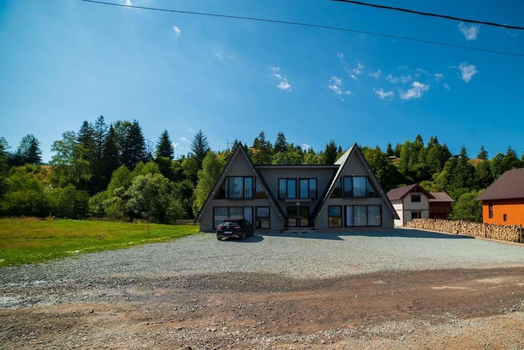 Cabana din Vale Arieșeni – cabanele în stil A-frame, văzute din curte Cabana din Vale Arieșeni – cabanele în stil A-frame, văzute din curte
