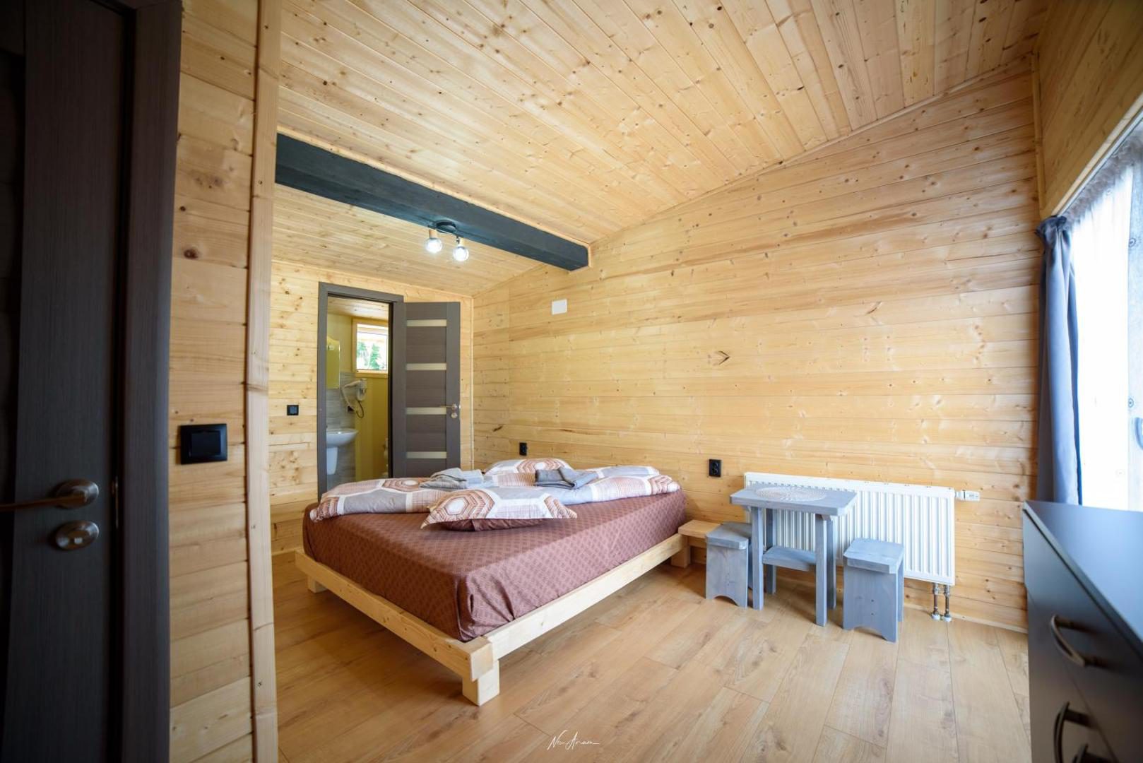 Cabana din Vale Arieșeni – cameră cu pereți de lemn și pat matrimonial Cabana din Vale Arieșeni – cameră cu pereți de lemn și pat matrimonial