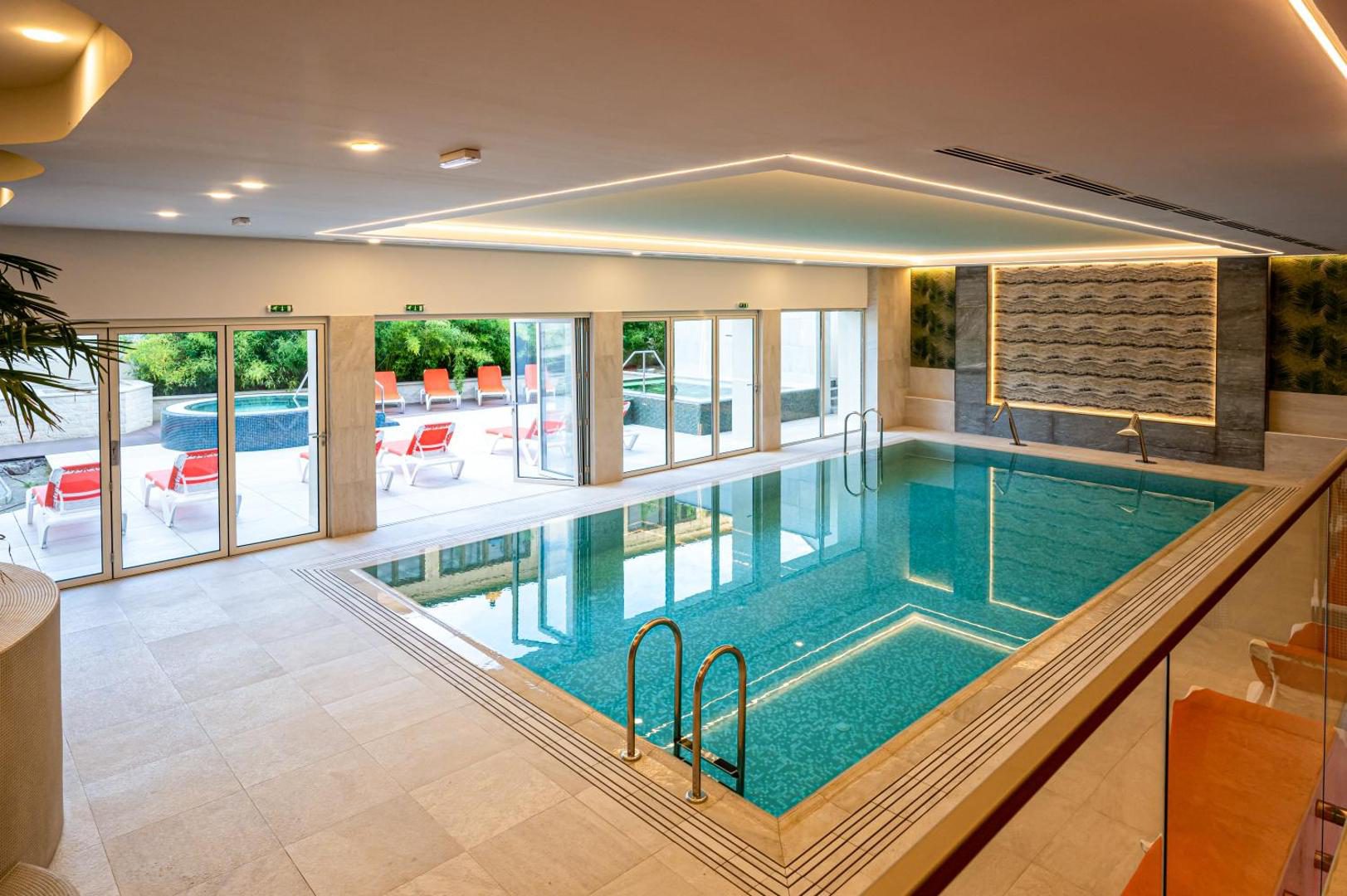 Piscina interioară de la Hotel Carolin, cu ușile deschise spre terasă Piscina interioară de la Hotel Carolin, cu ușile deschise spre terasă
