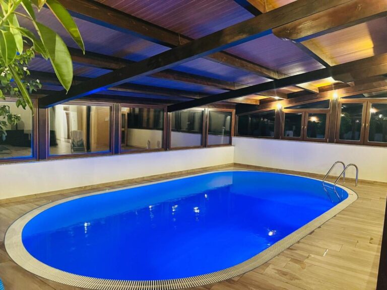 PENSIUNEA SKY HUB – piscina interioară seara, sub tavanul de lemn