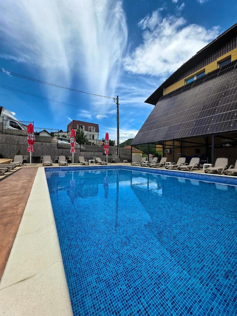 Hotel Select Băile Olănești – piscina exterioară cu șezlonguri, lângă clădirea hotelului Hotel Select Băile Olănești – piscina exterioară cu șezlonguri, lângă clădirea hotelului
