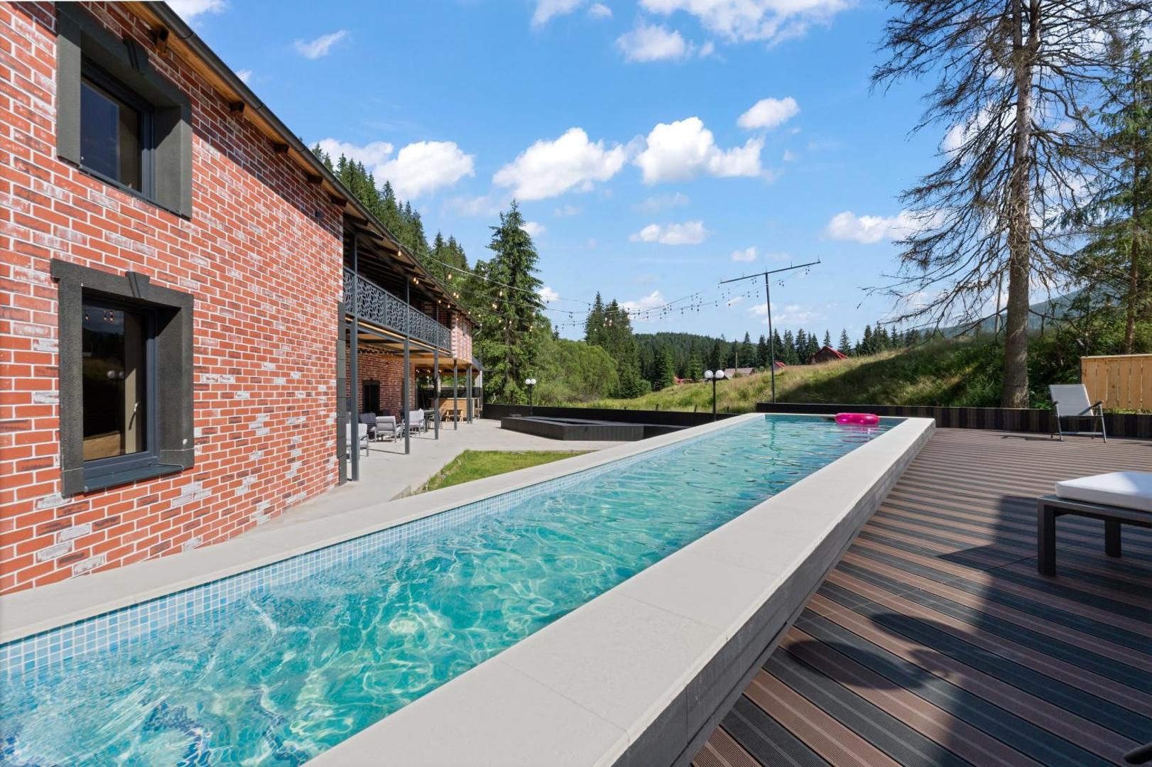 Transylvania House – piscina exterioară lungă, de-a lungul clădirii de cărămidă Transylvania House – piscina exterioară lungă, de-a lungul clădirii de cărămidă
