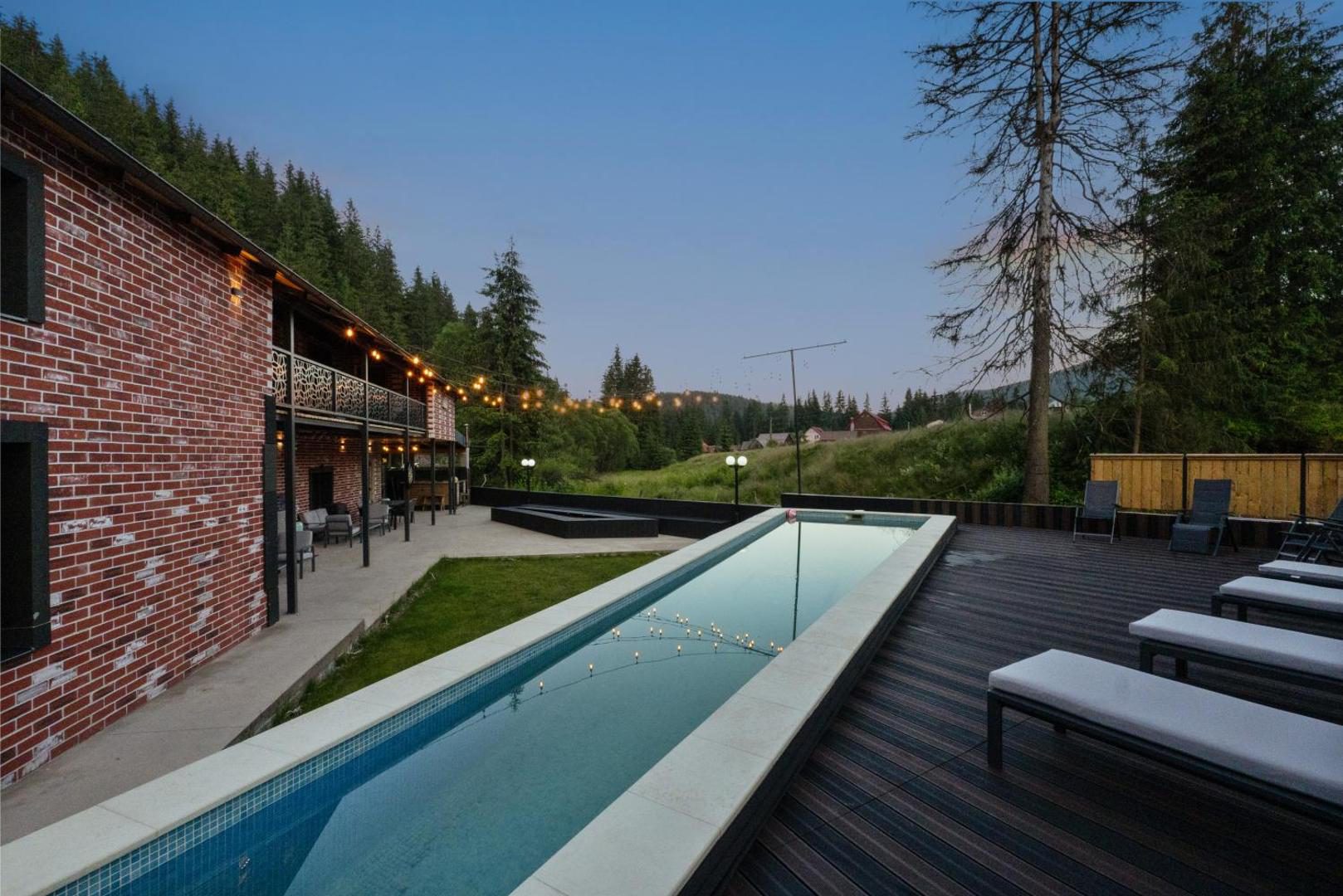 Transylvania House – șezlonguri pe terasa de lemn de lângă piscină Transylvania House – șezlonguri pe terasa de lemn de lângă piscină