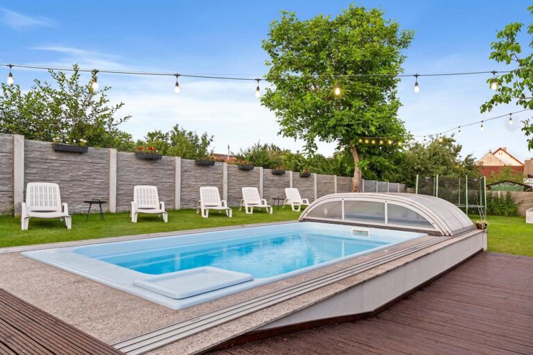 Pensiunea Alina Sibiu – piscina exterioară încălzită cu copertina retrasă și șezlonguri pe gazon